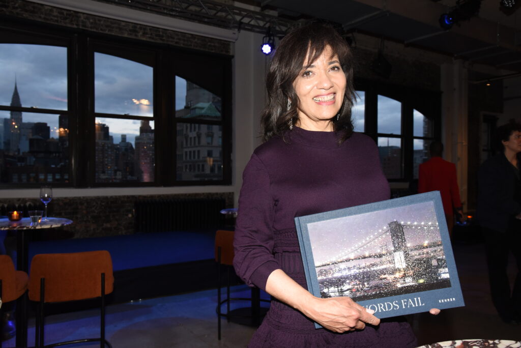 Pamela Thomas-Graham holding first edition copy of When Words Fail, New York twilight photography book