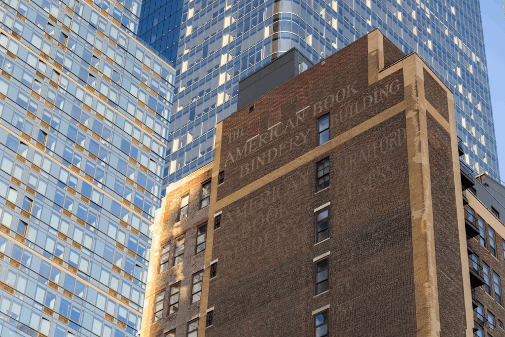 Manhattan West and Hudson Yards skyscrapers glowing gold at sunset with deep blue sky above