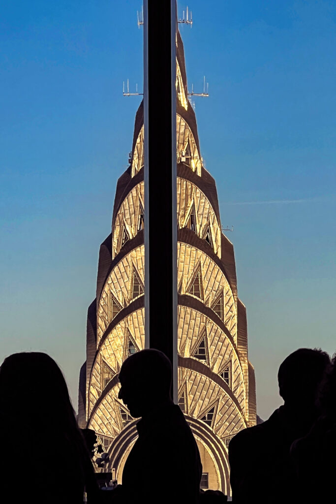 Chrysler Building illuminated against indigo sky.