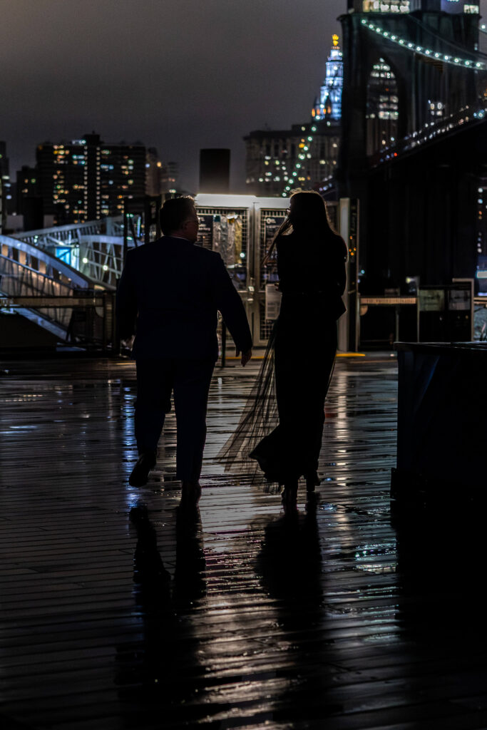 Couple walking at dusk under city lights.